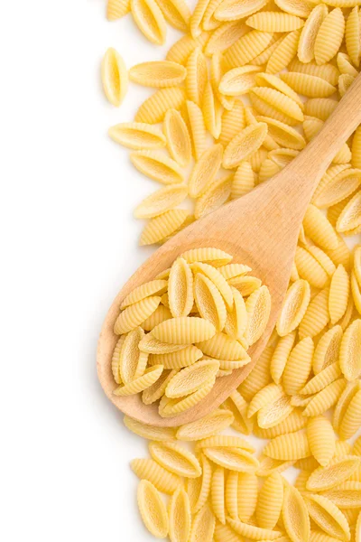 Uncooked italian pasta in wooden spoon — Stock Photo, Image