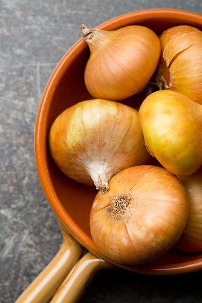 Raw onions in bowl — Stock Photo, Image