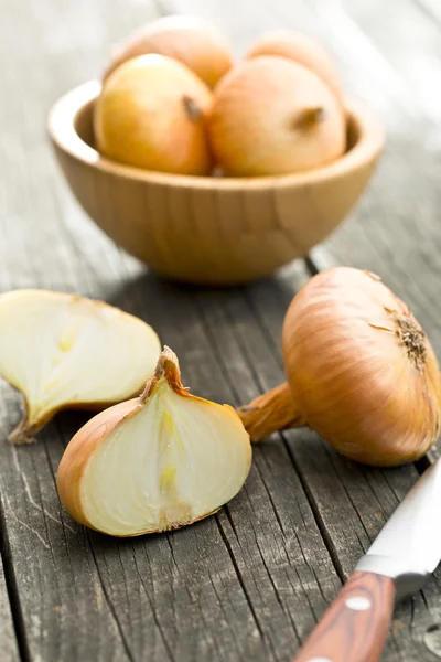 Cebolla fresca a la mitad en la mesa de madera — Foto de Stock