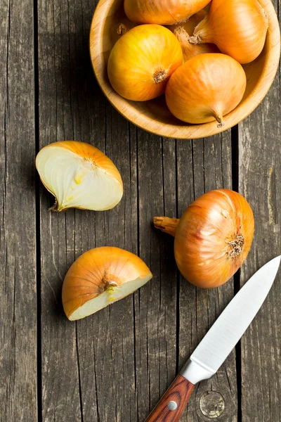 Oignon frais coupé en deux sur une table en bois — Photo