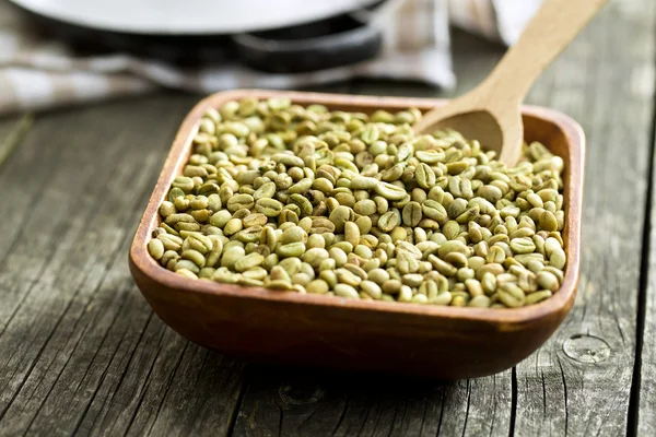 Granos de café verdes en tazón de madera — Foto de Stock