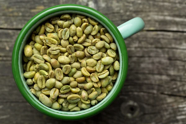 Grains de café non torréfiés dans une tasse — Photo