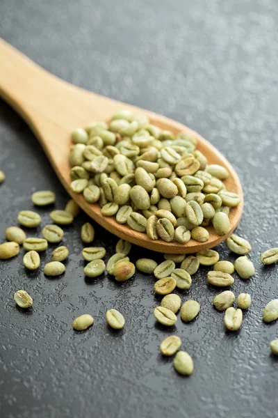 Зеленые кофейные зерна в ложке — стоковое фото