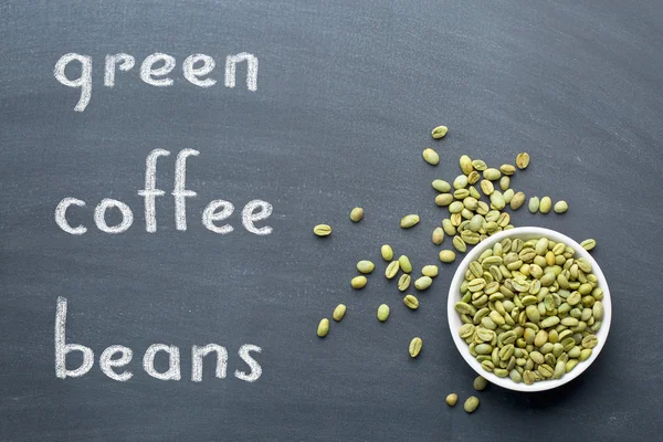 Green coffee beans on blackboard — Stock Photo, Image