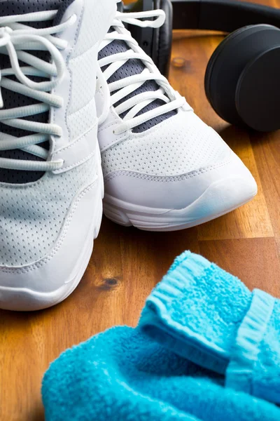 Concepto deportivo. auriculares, zapatos y toallas — Foto de Stock