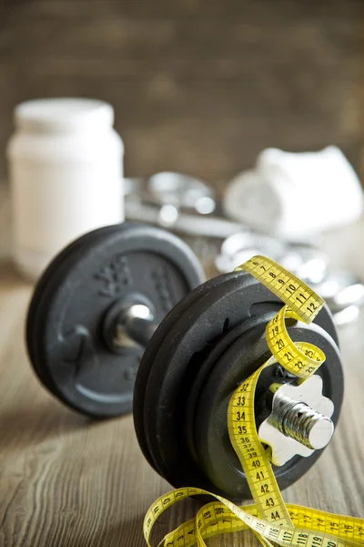 Measuring tape and iron dumbbell — Stock Photo, Image