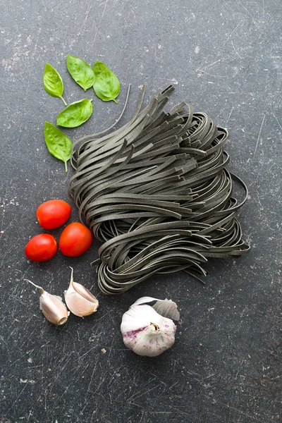 Nudeln, Knoblauch, Tomaten und Basilikumblätter — Stockfoto