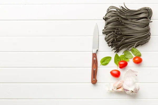 Macarrão, alho, tomates e folhas de manjericão — Fotografia de Stock