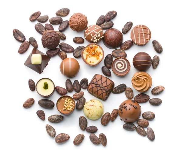 Various chocolate pralines and cocoa beans — Stock Photo, Image