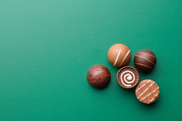 Čokoládové pralinky na zelenou tabuli — Stock fotografie