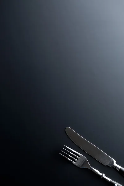 Gabel und Messer auf schwarzem Hintergrund — Stockfoto