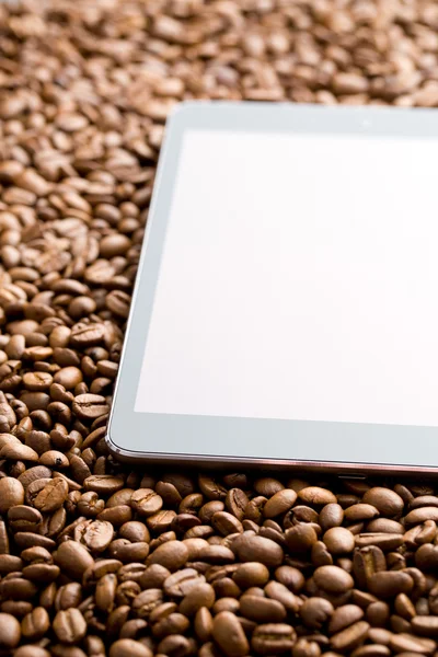 Tableta de ordenador en granos de café — Foto de Stock