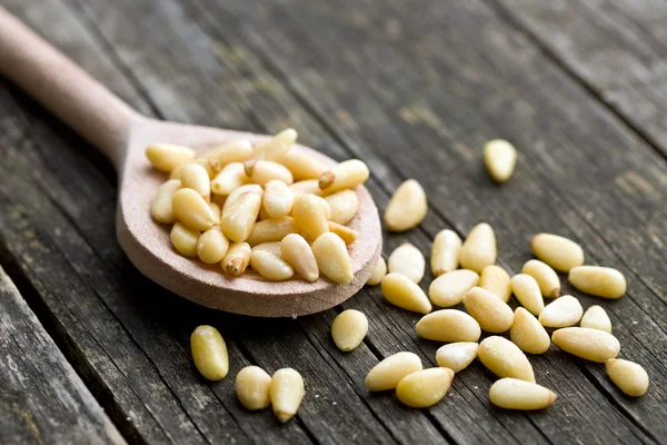 Pine nuts on wooden spoon — Stock Photo, Image