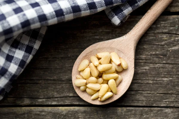 Сосновые орехи на деревянной ложке — стоковое фото