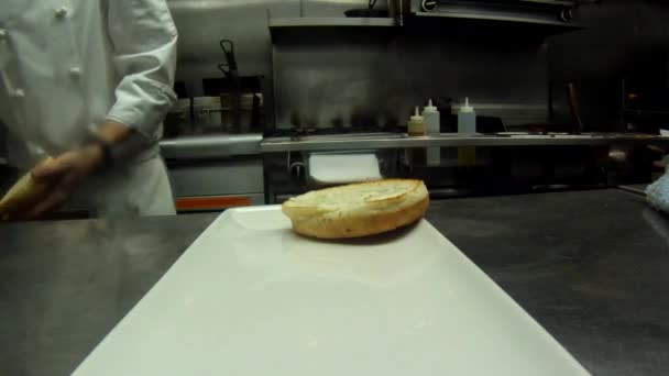 Koch bereitet einen Burger zu — Stockvideo