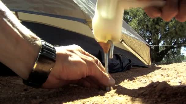 Camper Drives Tent Pegs — Stock Video
