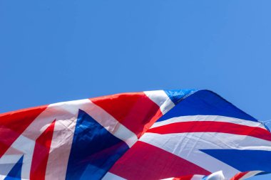 Birleşik Krallık bayrağı rüzgarda dalgalanıyor mavi gökyüzü arkaplanı ve kopyalama alanı