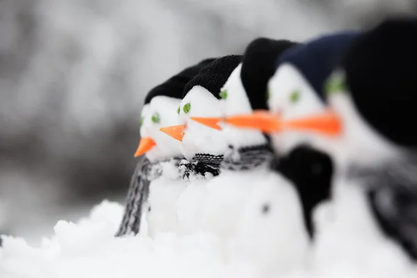 Fila de muñecos de nieve mirando a la izquierda — Foto de Stock