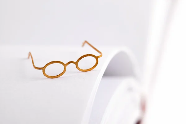 Lectura de gafas en una página blanca — Foto de Stock
