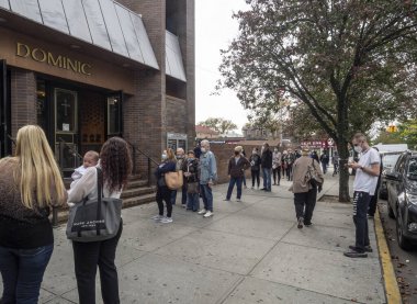 Brooklyn, New York, ABD - 24 Ekim 2020: St. Dominic Katolik Kilisesi, Brooklyn 'de Coronavirus salgınının ortasında erken başkanlık seçimleri için sırada bekleyenler.