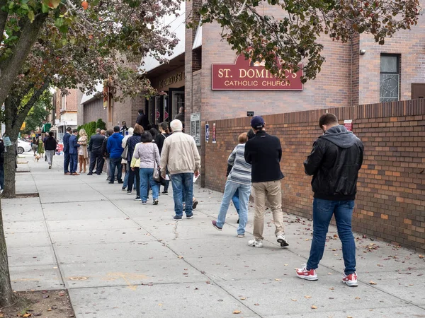 Brooklyn, New York, ABD - 24 Ekim 2020: St. Dominic Katolik Kilisesi, Brooklyn 'de Coronavirus salgınının ortasında erken başkanlık seçimleri için sırada bekleyenler.
