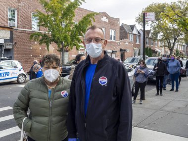 Brooklyn, New York, ABD - 27 Ekim 2020: Seçmenler Coronavirus salgınının ortasında Brooklyn 'deki St. Dominic Katolik Kilisesi' nde erken genel oylama için oy kullandıktan sonra sandık merkezinden çıktılar.
