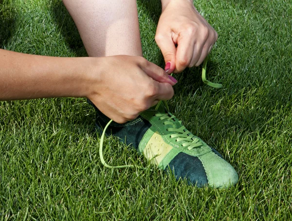 Жінка зв'язує мережива на спортивному взутті Стокове Зображення