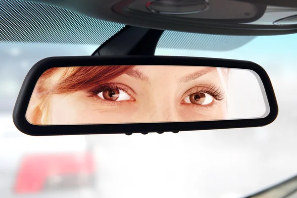 Woman looks to rear-view mirror — Stock Photo, Image