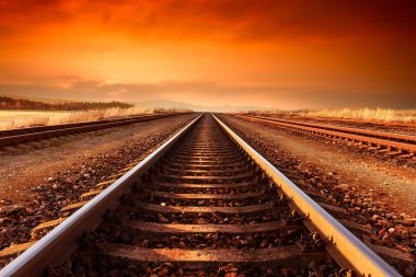 Tren rayları gider ufuk için görkemli günbatımı.