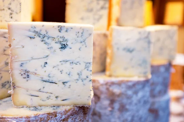 一堆堆整整整齐齐的Stilton奶酪在市场上出售这是一种流行的英国蓝奶酪 添加了青霉 形成了特有的蓝色血管 — 图库照片