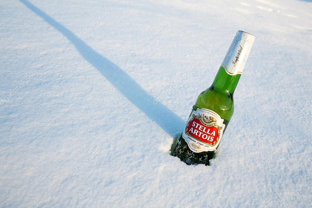 MONTREAL, CANADA - January 21, 2015: A bottle of Stella Artois beer cools in the winter snow. A European pilsner beer, very popular in Canada. Montreal