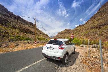 White Nissan Juke in the mountain scenery of Canaries clipart