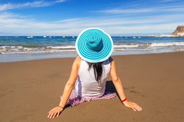 Kvinna i hatt njuter av solen semester på stranden — Stockfoto