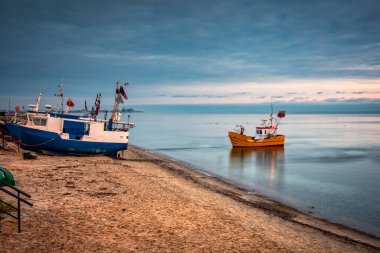Mekanik köyünde güneş doğmadan önce balıkçı teknesi, kuzey Polonya.