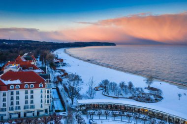Kışın Sopot 'ta karlı plajda güzel bir gün batımı ve iskele (Molo). Polonya