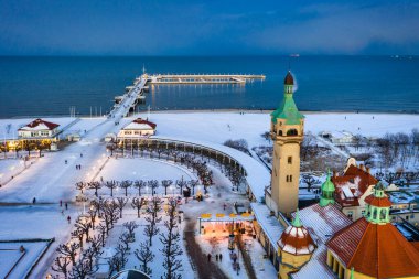 Kışın alacakaranlıkta Sopot 'ta karlı sahil ve iskele (Molo). Polonya