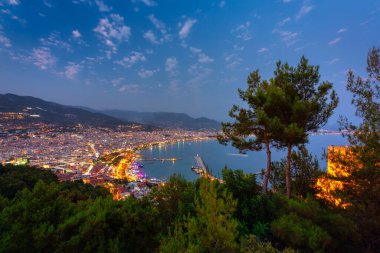 Alacakaranlıkta Akdeniz kıyısındaki Alanya şehir manzarası. Türkiye