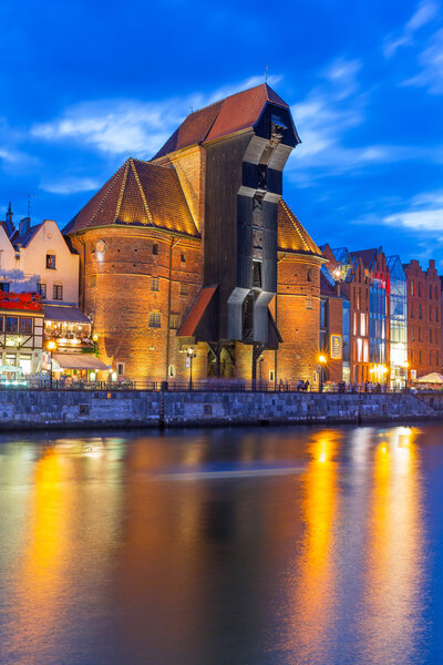 Medieval port crane over Motlawa river at night