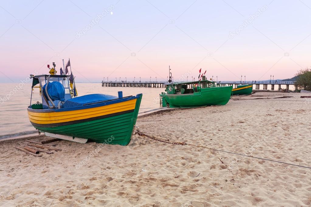 Baltic beach with fishing boat at sunset