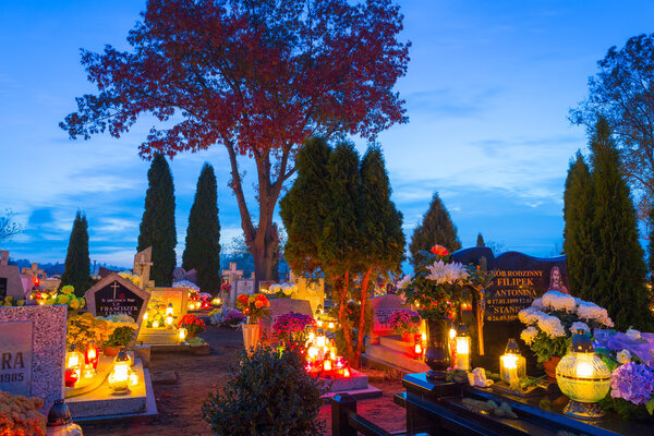 Cemetary at night with colorful candles for All Saints Day