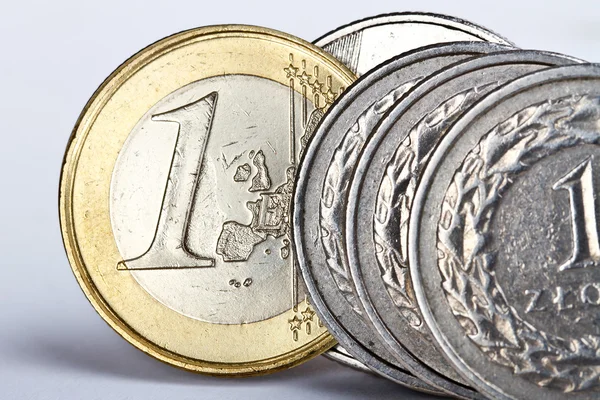 Één euro en een zloty munt — Stockfoto