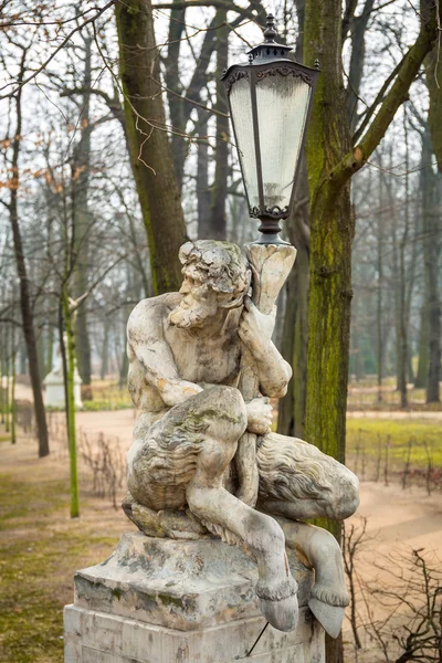 Lantaarn ingericht door sculptuur van satyr in Koninklijke Baden Park van Warschau — Stockfoto