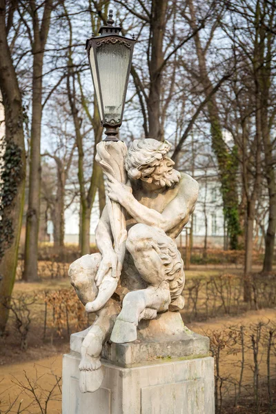 Lantern decorated by sculpture of satyr in Royal Baths Park of Warsaw — Stock Photo, Image