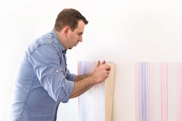 Handyman putting up wallpaper — Stock Photo, Image