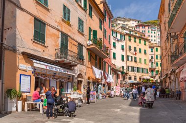 People walking on the street of Riomaggiore village in Italy clipart
