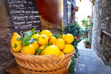 Wicker basket full of lemons on the street of Italy clipart