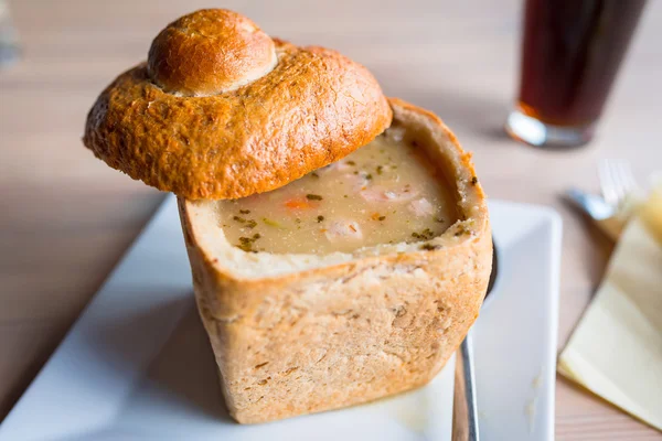 Leckere Suppe in gebackener Brotschale serviert — Stockfoto