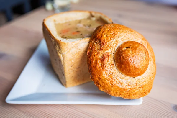 Leckere Suppe in gebackener Brotschale serviert — Stockfoto