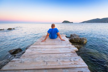 Man watching sunset over ionian sea