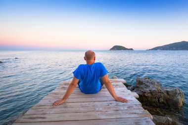 Man watching sunset over ionian sea
